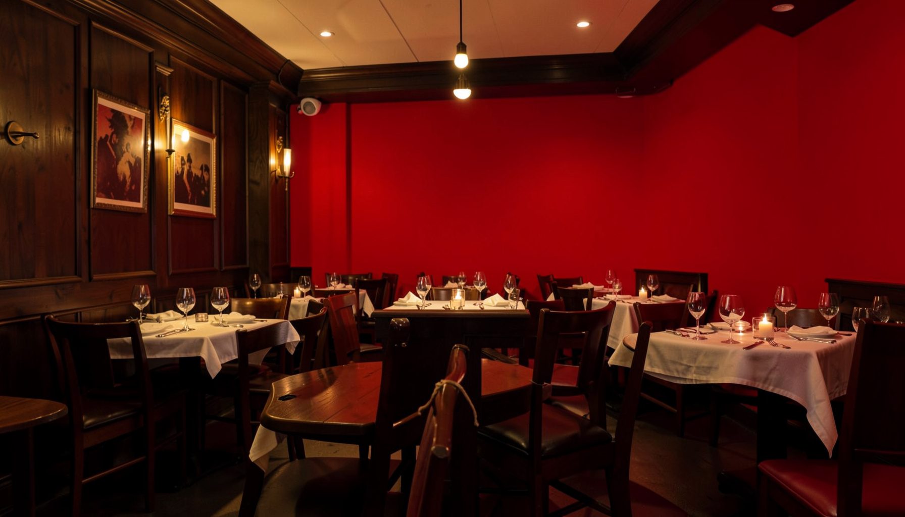 Warm ambient interior of a restaurant dining room with soft golden lighting and dark wood accents