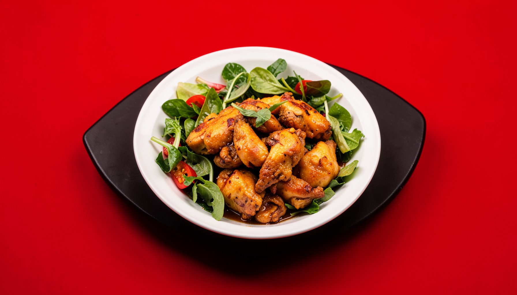 Warm-toned overhead shot of a plated comfort-food dish with golden chicken and fresh greens on a dark table
